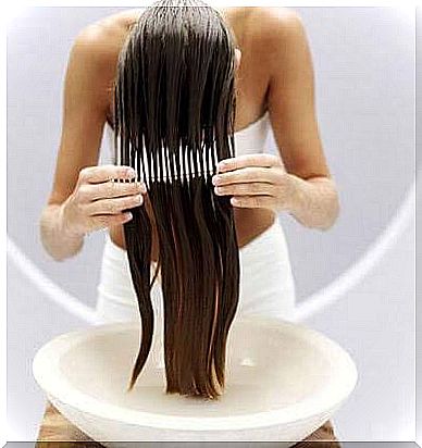 A woman brushing her wet hair with a comb