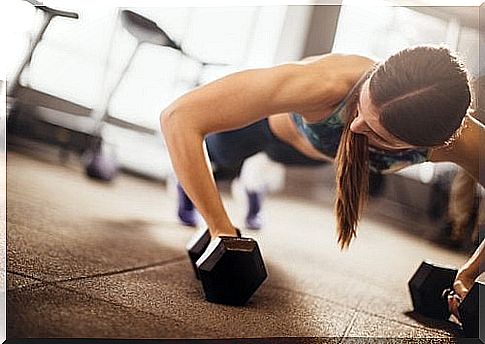 woman doing push-ups with dumbbells