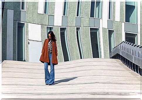 the woman descends the stairs in the bells;  flared jeans