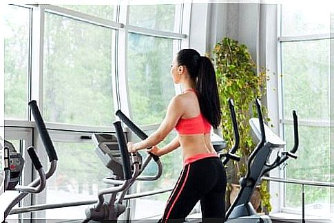 the woman on an elliptical cross trainer is exercising