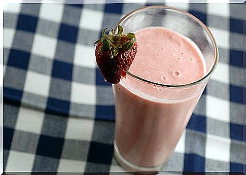 a nutritious smoothie with strawberries on a vichy plaid tablecloth