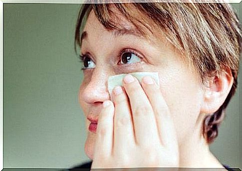 The woman applies a compress to her swollen eyelids