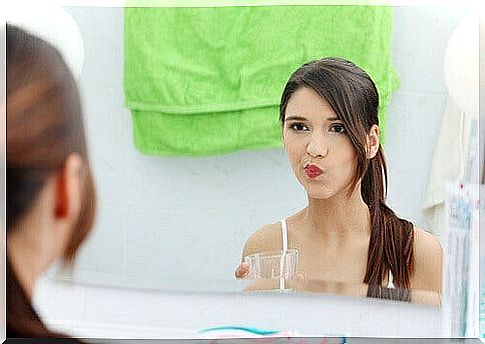 a woman rinsing her mouth with a fluid for mouth ulcers